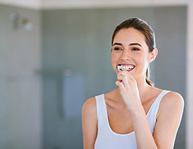Woman smiling and brushing her teeth