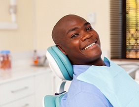 Man in dental chair smiling and waiting for dentist