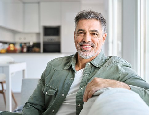 Man smiling while relaxing on couch