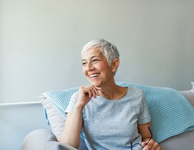 Woman smiling while relaxing on couch at home