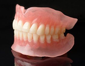 Full set of dentures shown against dark background