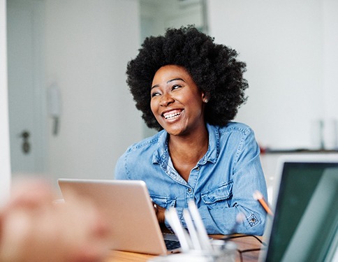 person working on their laptop and smiling