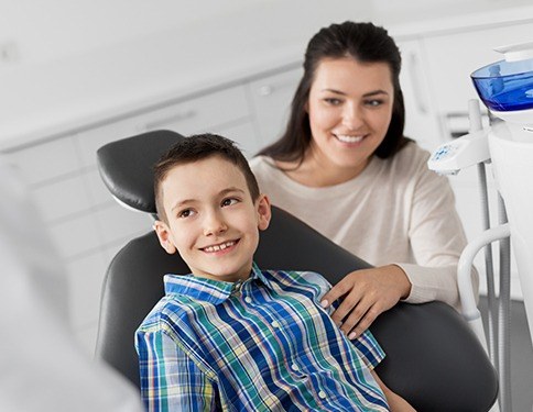 Child and his mother smiling at dental checkup