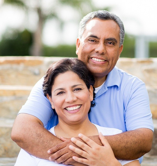 Smiling older man and woman after dental crown restoration