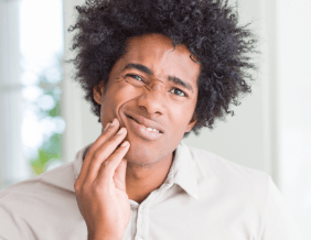 Man with toothache holding cheek