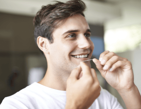 Man flossing teeth to prevent dental emergencies