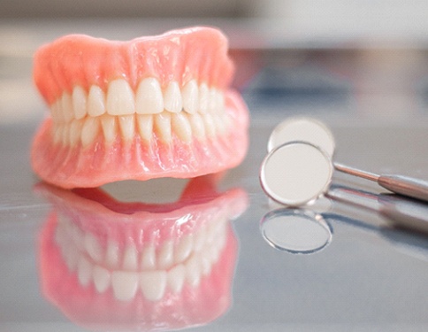 dentures sitting on a counter next to dental tools