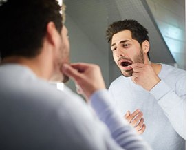 Patient in Tyler checking dental implants in the mirror