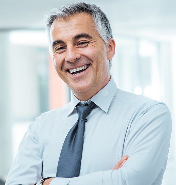 Older man smiling after replacing missing teeth