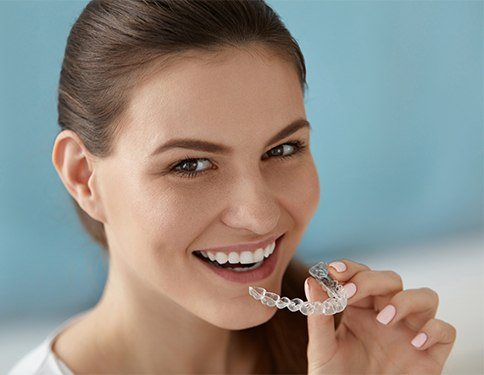 Teen girl placing Invisalign tray