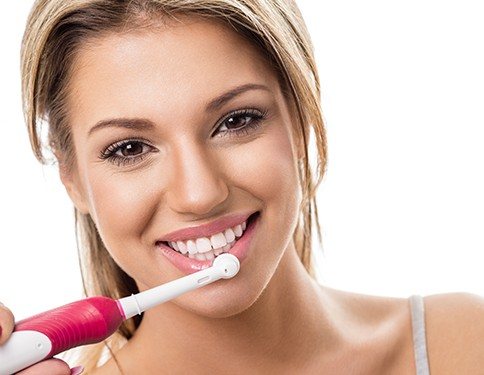 Woman using electric toothbrush