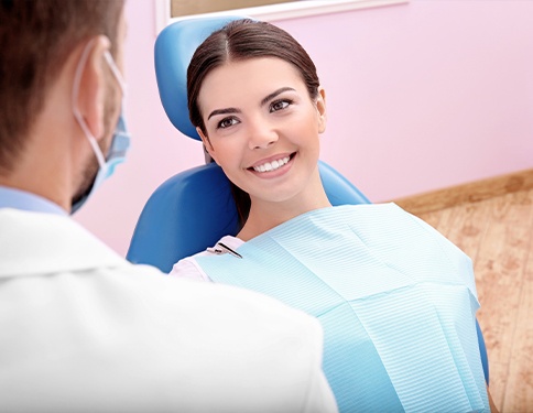 Relaxed woman in dental chair smiling at dentist