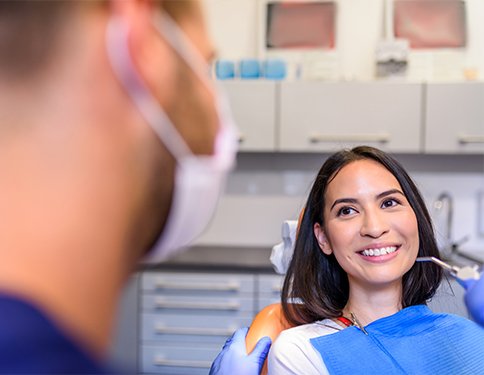 Woman in dental chair smiling at dentist