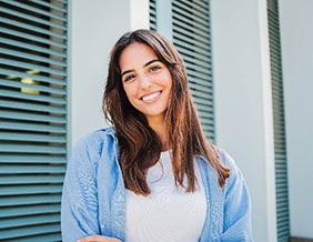 Woman with white teeth smiling while standing outside