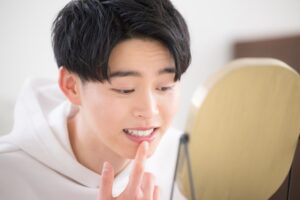 Man looking at his gums in the mirror